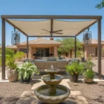 A shaded patio oasis in a Mesa backyard with a pergola, outdoor fans, and a bubbling fountain.
